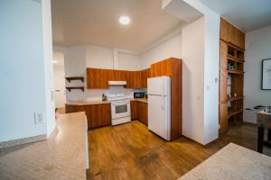 een keuken met een witte koelkast en houten kasten bij Le loft Charlotte 2 in Québec