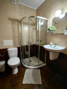 a bathroom with a shower and a toilet and a sink at Niko Apartments in Sunny Beach