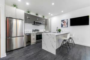 a kitchen with a stainless steel refrigerator and a counter at Celeste Rooftop Villa in New Orleans