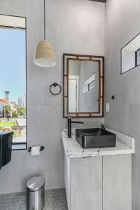 a bathroom with a sink and a mirror at Celeste Rooftop Villa in New Orleans