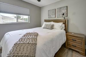 Un dormitorio con una gran cama blanca y una ventana en Manasota Key Home with Screened Porch Walk to Beach, en Englewood