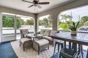 un porche cubierto con mesa y sillas en Manasota Key Home with Screened Porch Walk to Beach, en Englewood