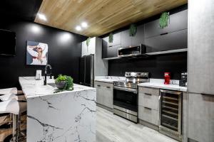 a kitchen with black walls and marble counter tops at Pluto Rooftop Villa in New Orleans
