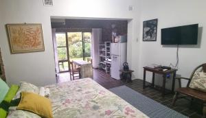 ein Wohnzimmer mit einem Bett und einem TV in der Unterkunft Secret Sithela in Port Edward