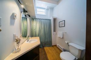 a bathroom with a sink and a toilet and a mirror at Les lofts Charlotte in Quebec City