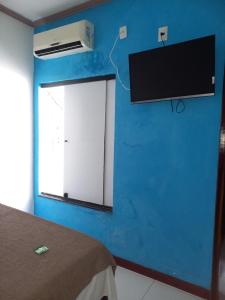 - une chambre dotée d'un mur bleu et d'une télévision murale dans l'établissement HOTEL AL MARE ATLANTICO, à Aracaju