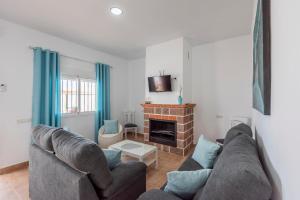 a living room with a couch and a fireplace at Casa Rural Lola - Lantejuela in La Lantejuela