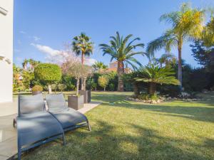een stoel op het gras in een tuin bij Villa del Prado Private Pool Large Garden in Marbella