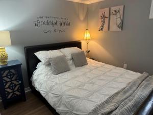 1 dormitorio con 1 cama con sábanas y almohadas blancas en Lazy Days Vacation Rental, en Picton
