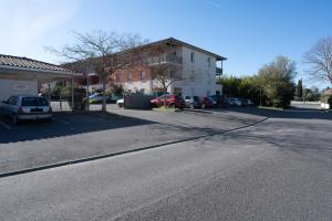 een lege straat met auto's geparkeerd op een parkeerplaats bij Le Jardin des Chimères in Castanet-Tolosan