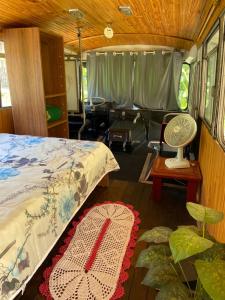 um quarto com uma cama e um tapete num quarto em Chalé Bus Ponto Z em São Bento do Sapucaí