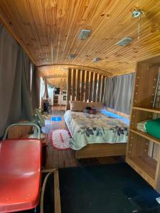 um quarto com uma cama e um tecto de madeira em Chalé Bus Ponto Z em São Bento do Sapucaí