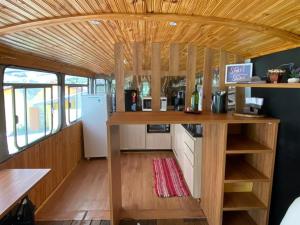 a kitchen in a tiny house with a wooden ceiling at Chalé Bus Ponto Z in São Bento do Sapucaí