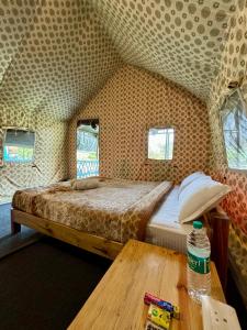 a bedroom with a bed and a wooden table at Kodom Bari Retreat, Kaziranga in Kāziranga