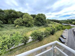 un balcón con vistas a un aparcamiento con coches en Charmant logement avec parking privé., en Veules-les-Roses