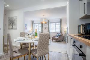 a kitchen and dining room with a table and chairs at Luxurious Apartment Charlton Mews - 2 Bed - Tenby in Tenby