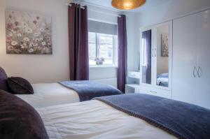 1 dormitorio con 2 camas y ventana en Luxurious Apartment Charlton Mews - 2 Bed - Tenby en Tenby