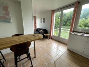 Una cocina y una sala de estar con mesa y sillas. en Charmant logement avec parking privé., en Veules-les-Roses 8 fotos más