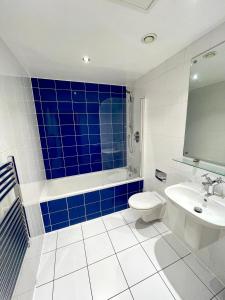 a bathroom with a toilet and a tub and a sink at Chic Leeds City Apartment, Free Parking, Balcony in Leeds