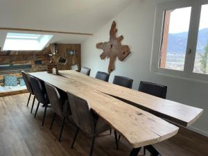un comedor con una gran mesa de madera y sillas en Magnifique appartement Savoie Vue montagne* en Saint-Baldoph