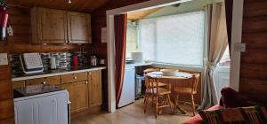 a kitchen with a small table and a kitchen with a window at Snowdonia National park Log cabin with garden in Trawsfynydd