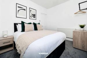 una camera da letto con un grande letto con cuscini verdi di NEW Sackville House - Comfy 4 Bedroom House a Stoke on Trent