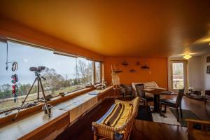 ein Wohnzimmer mit einem großen Fenster und einem Tisch in der Unterkunft Le Remous in La Malbaie