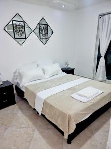a bedroom with a bed with two towels on it at Hermosa casa en Bucaramanga in Bucaramanga