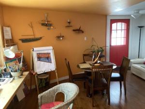 a living room with a table and chairs and a red door at Le Remous in La Malbaie