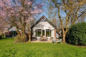 een huis met een tafel en stoelen in een tuin bij Enjoy Heuvelland in Simpelveld