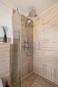 een douche met een glazen deur in de badkamer bij Enjoy Heuvelland in Simpelveld