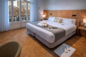 una habitación de hotel con una cama grande y una silla en Hotel SERHS Rivoli Rambla, en Barcelona