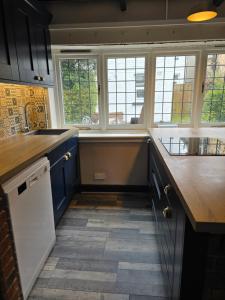 a kitchen with blue cabinets and a counter top at Bournemouth secluded cottage 10mins walk to beach in Bournemouth