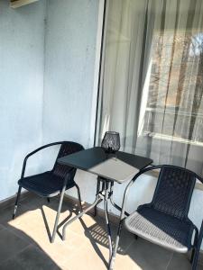 two chairs and a table in a room with a window at Niko Apartments in Sunny Beach