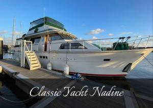 a white boat is docked at a dock at Classic Yacht Nadine in Poole Harbour, Dorset, with a Hot Tub Jacuzzi in Poole