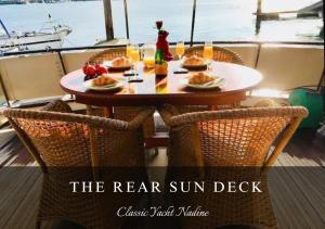 a table on a boat with food on it at Classic Yacht Nadine in Poole Harbour, Dorset, with a Hot Tub Jacuzzi in Poole