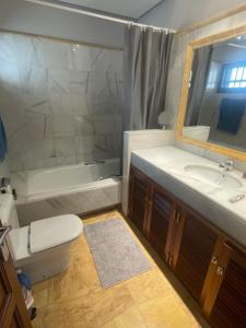 ein Badezimmer mit Toilette, Waschbecken und Badewanne in der Unterkunft Faro Park Villa Bella heated Pool in Playa Blanca + 20 Fotos