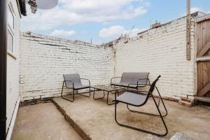 two chairs and a table in front of a brick wall at Perfect Modern 4 bedroom in Liverpool in Liverpool