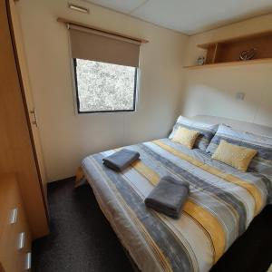 1 dormitorio con 1 cama grande y 2 toallas. en Yarborough View 1 Whitecliff Bay Bembridge Isle of Wight, en Bembridge
