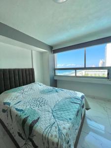 1 dormitorio con cama y ventana grande en Departamento con vista al mar, en Mazatlán