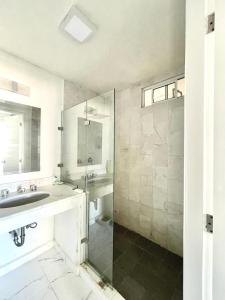 a bathroom with a sink and a glass shower at Departamento con vista al mar in Mazatlán