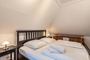 - une chambre avec 2 lits dotés de draps et d'oreillers blancs dans l'établissement Ferienwohnung Krakow am See, à Krakow am See