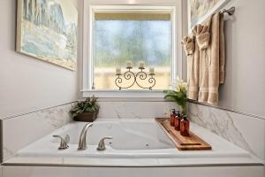 a white sink in a bathroom with a window at Copper Creek Retreat - Hot Tub - Fenced In Yard in Fayetteville