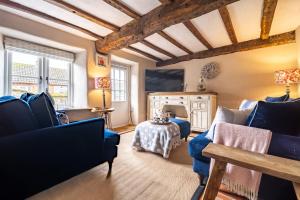 a living room with two couches and a table at Fox Cottage in South Creake