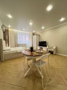 a living room with a table and chairs and a couch at Байзакова 133 in Pavlodar
