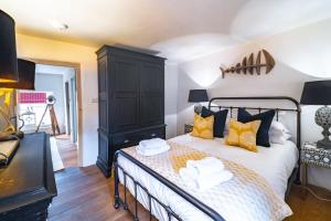 a bedroom with a bed with yellow and black pillows at Fox Cottage in South Creake