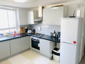 eine Küche mit weißen Schränken und einem weißen Kühlschrank in der Unterkunft Double Room Near Tower Bridge 403 in London