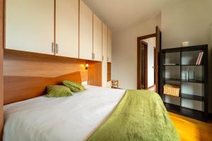 een slaapkamer met een groot bed en witte kasten bij Willow Apartment with Lakeview by Wonderful Italy in Gravedona