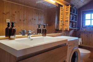 a bathroom with a white sink and wooden walls at Le Petit Chalet du Chinaillon in Le Grand-Bornand