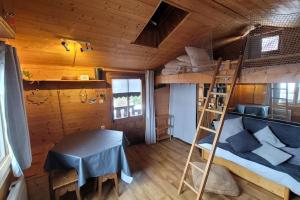 Etagenbett in einem Zimmer mit einem Tisch und einer Leiter in der Unterkunft Le Petit Chalet du Chinaillon in Le Grand-Bornand